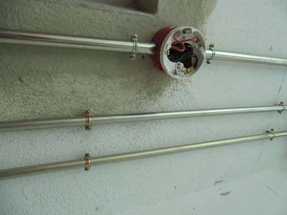 Aplicación de abrazadera metálica M6 L para fijación segura de tubos en instalaciones eléctricas