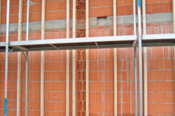 Aplicación del taco largo para mampostería HBR SSP en estructura de madera sobre pared de ladrillo