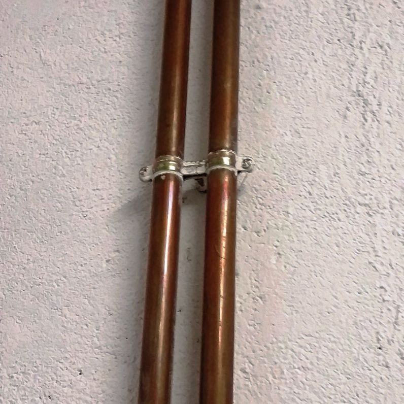 Aplicación de abrazadera metálica doble M6 AD para fijación segura de dos tuberías