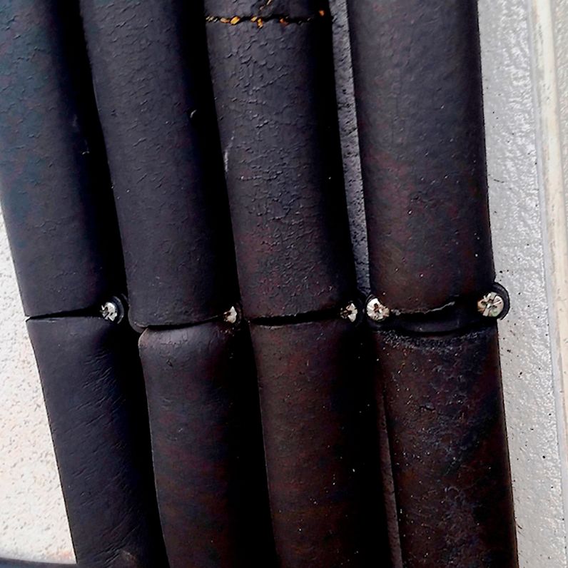 Imagen de aplicación de abrazaderas metálicas dobles gas M6 GD sujetando varias tuberías con aislamiento térmico mediante tornillos para instalación segura en pared