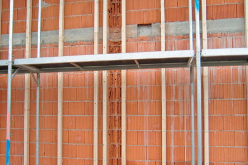 Aplicación del taco largo para mampostería HBR SSP en estructura de madera sobre pared de ladrillo