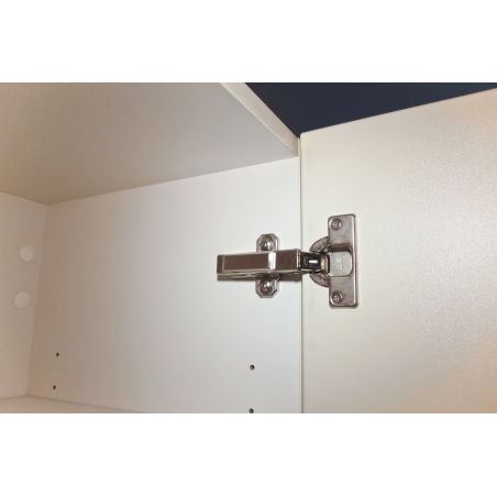 Bisagra metálica instalada en puerta de mueble de madera