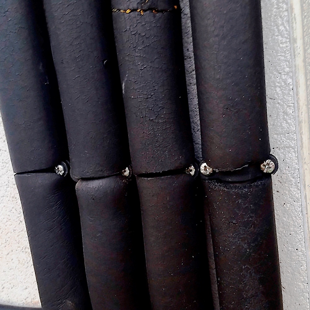Imagen de aplicación de abrazaderas metálicas dobles gas M6 GD sujetando varias tuberías con aislamiento térmico mediante tornillos para instalación segura en pared