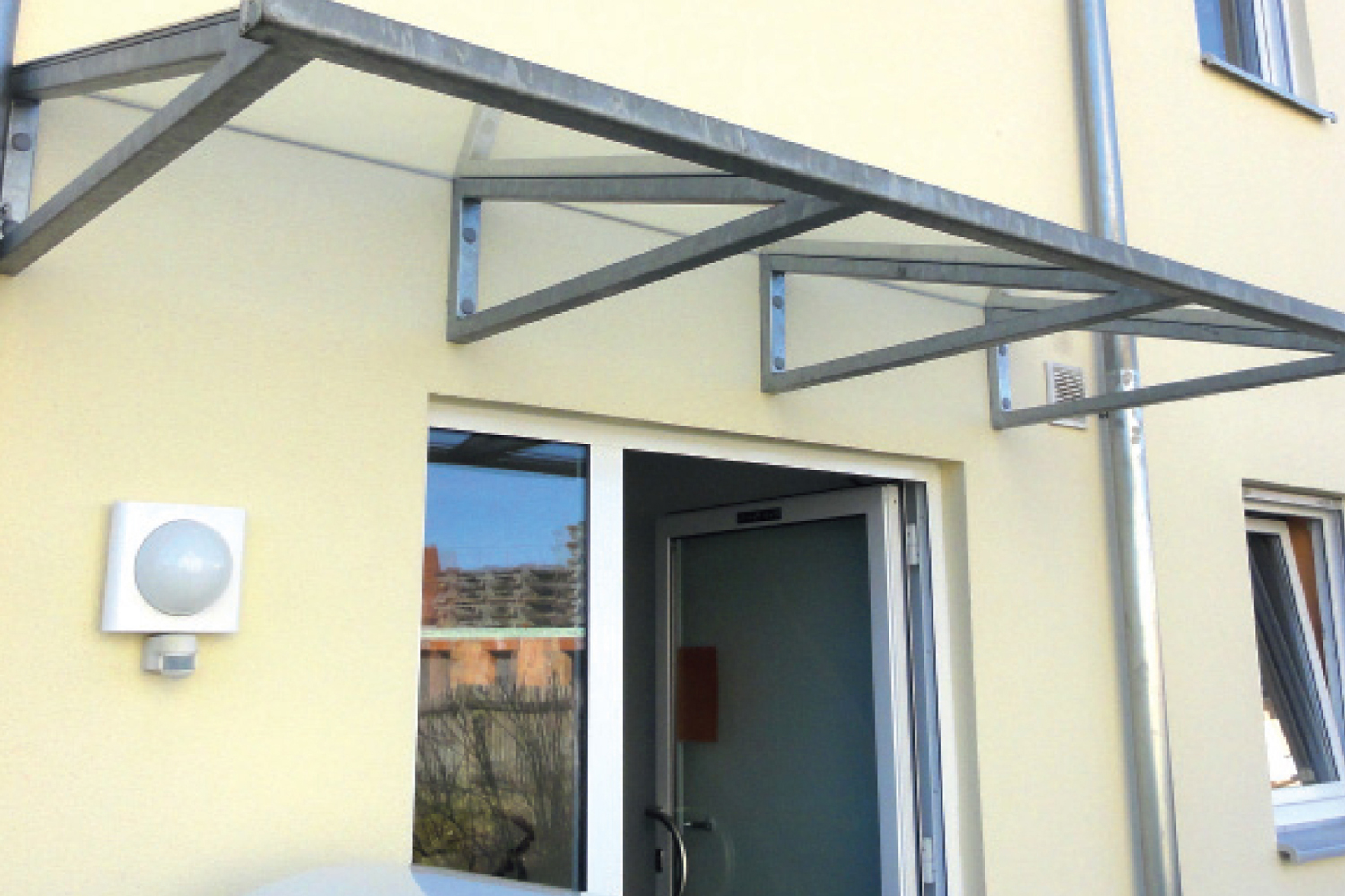 Imagen de aplicación del sistema de montaje con separación ResiTHERM: Fijación de un tejadillo en un ladrillo perforado con aislamiento
