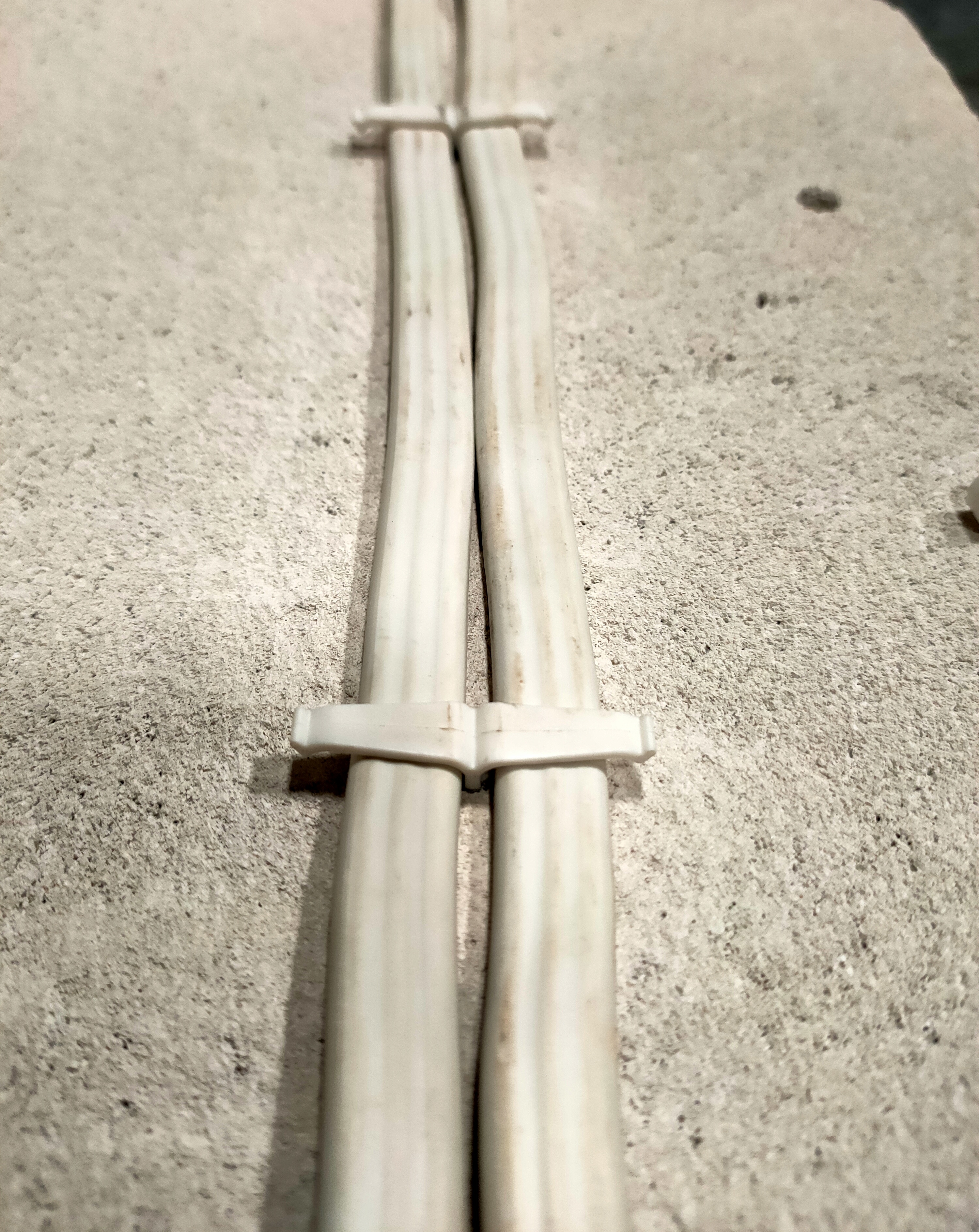 Fijación de cables planos con clips plásticos para organización segura