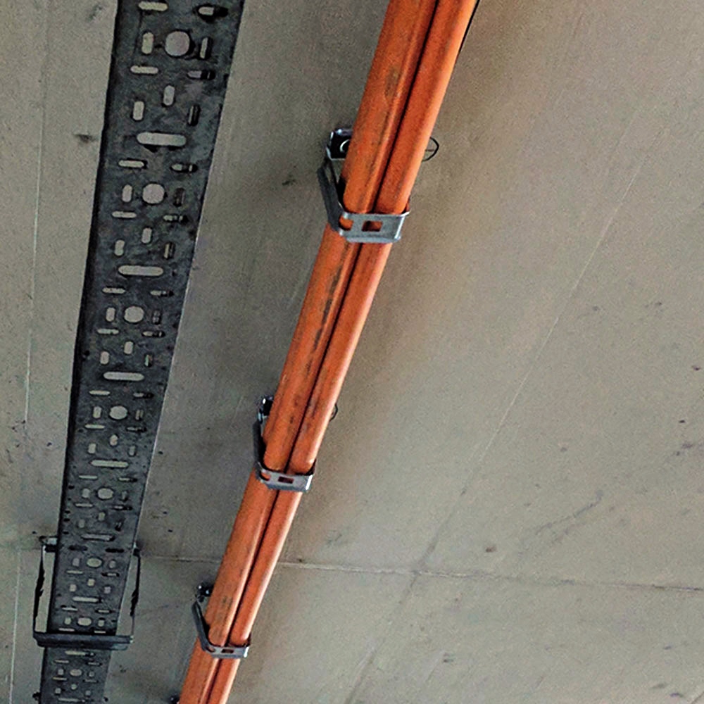 Abrazadera multicables metálica CH fijando conducciones en instalación de techo