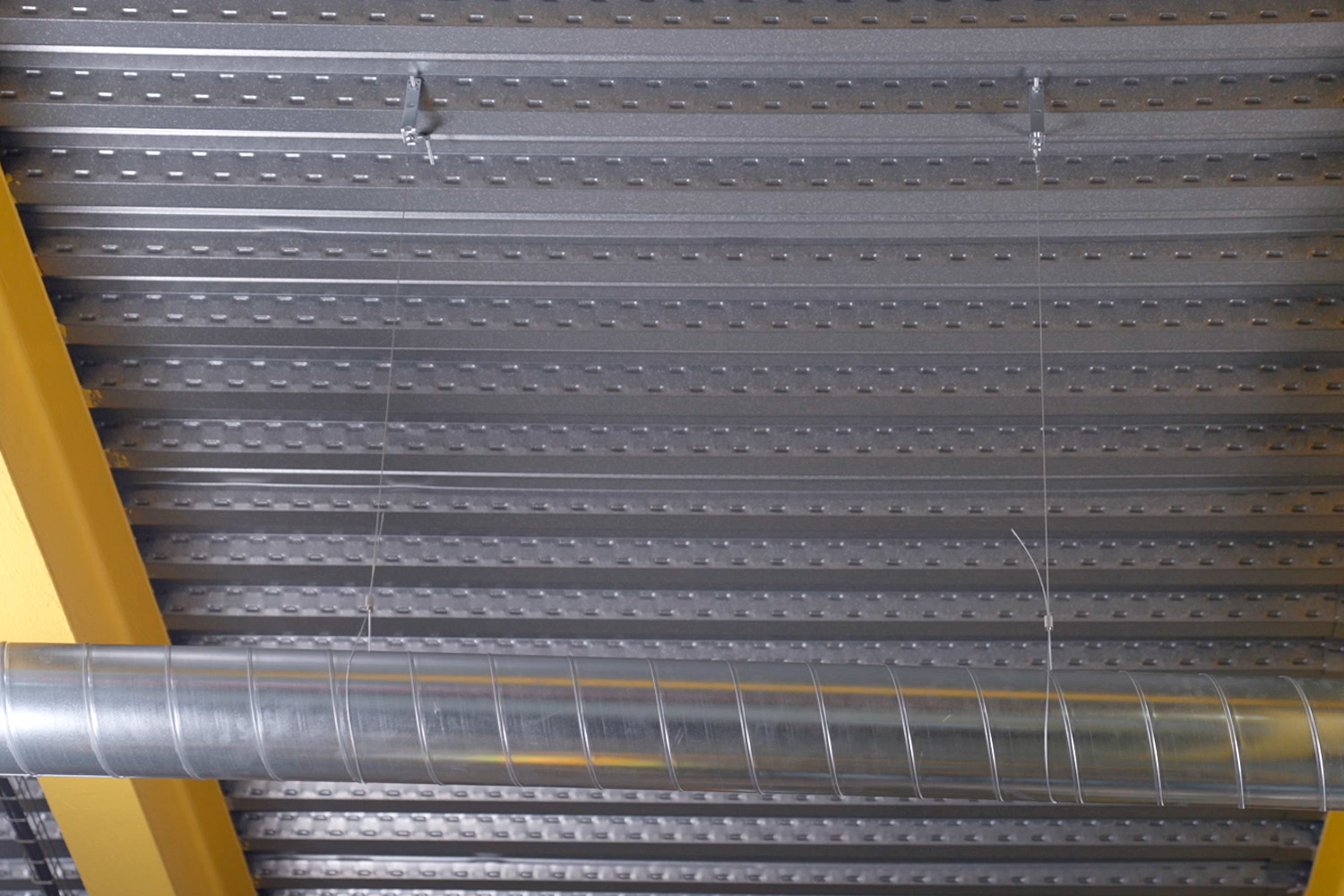 Aplicación cables de suspensión EWFS para conductos en techo industrial