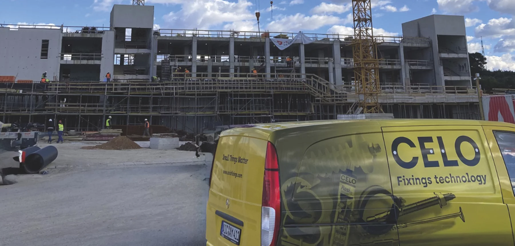 Una furgoneta CELO en frente de una obra de construcción
