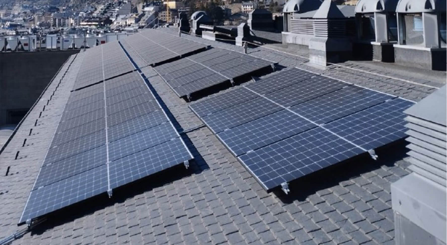 Placas solares instaladas con fijaciones y sujeciones CELO en la azotea del edificio de Illa Carlemany en Andorra