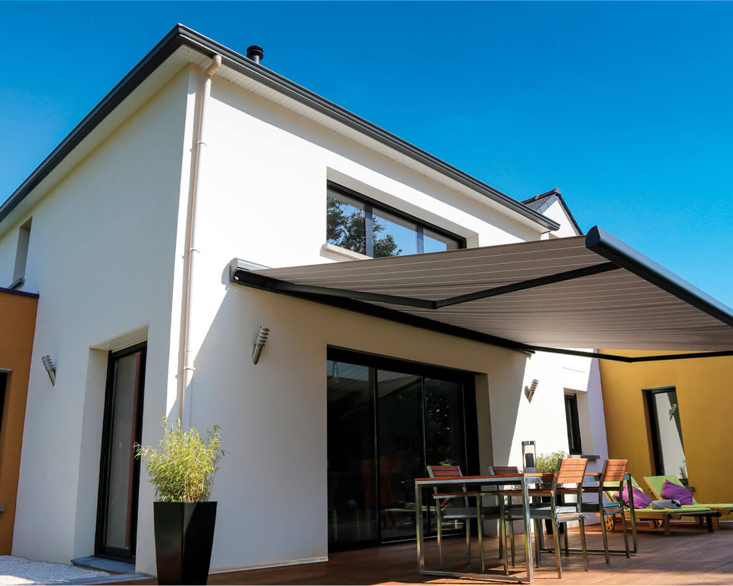 Vivienda con un toldo instalado con fijación a través de un sistema de aislamiento térmico exterior